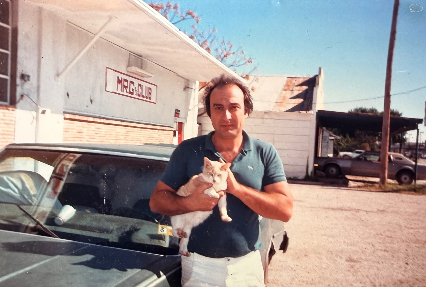 Family photograph of Paul’s father holding a cat outside the laundry